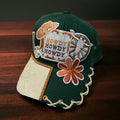Green Howdy hat by Southern Brim Works - deep green cap with Howdy patch, cowboy hat, wagon wheel, rust daisy, and tooled cream leather brim