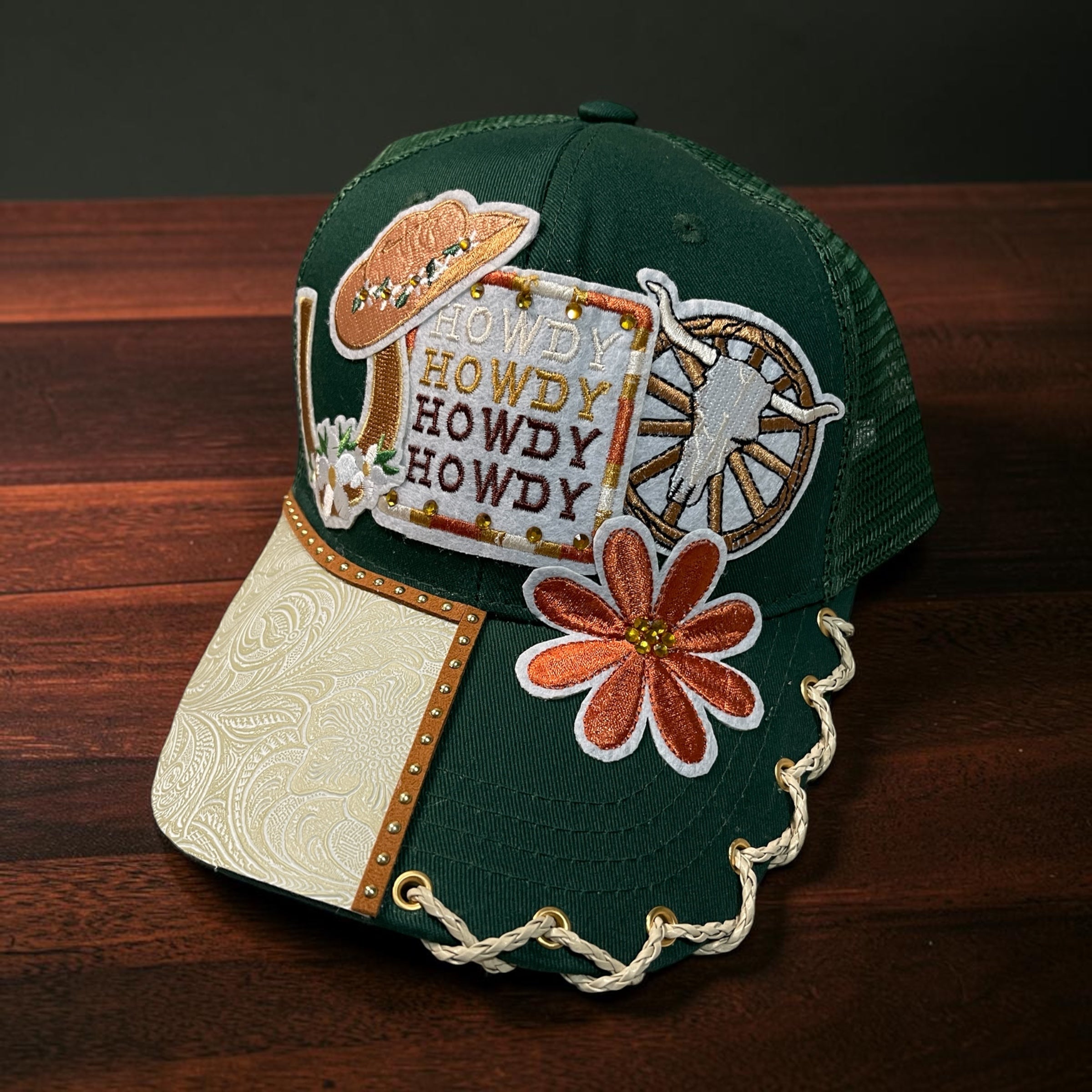 Green Howdy hat by Southern Brim Works - deep green cap with Howdy patch, cowboy hat, wagon wheel, rust daisy, and tooled cream leather brim